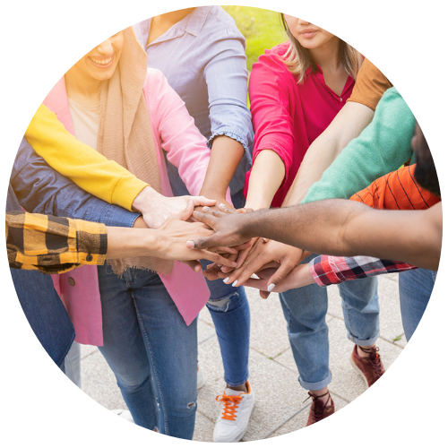 A diverse group of eleven people put their hands in for a high 5