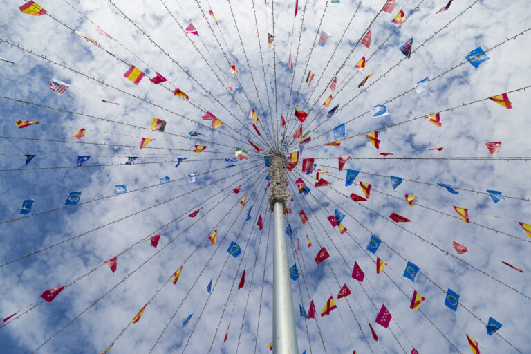 Many different international flags adorn steamers coming off a flagpole