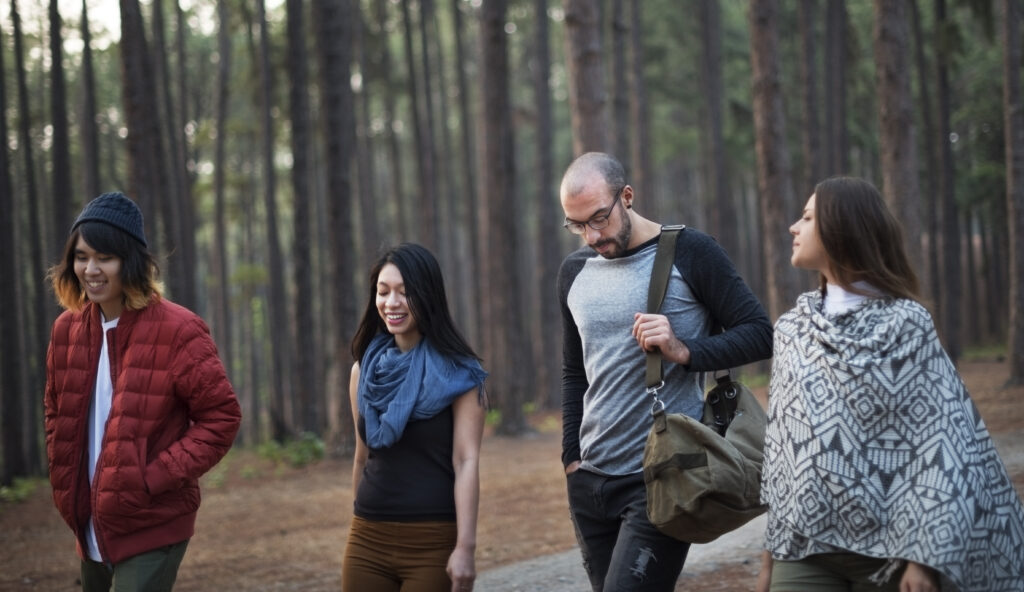 Four smiling people heading out on a walk in the forest